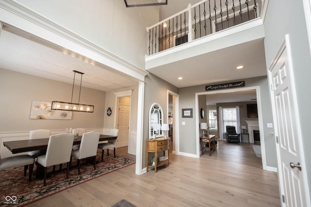 interior space with a towering ceiling and light hardwood / wood-style flooring