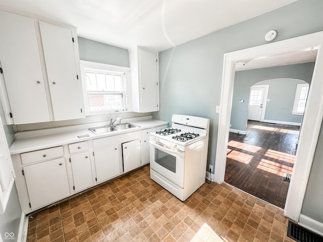 kitchen featuring white cabinetry, sink, plenty of natural light, and white gas range oven