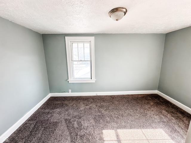 empty room with carpet flooring and a textured ceiling