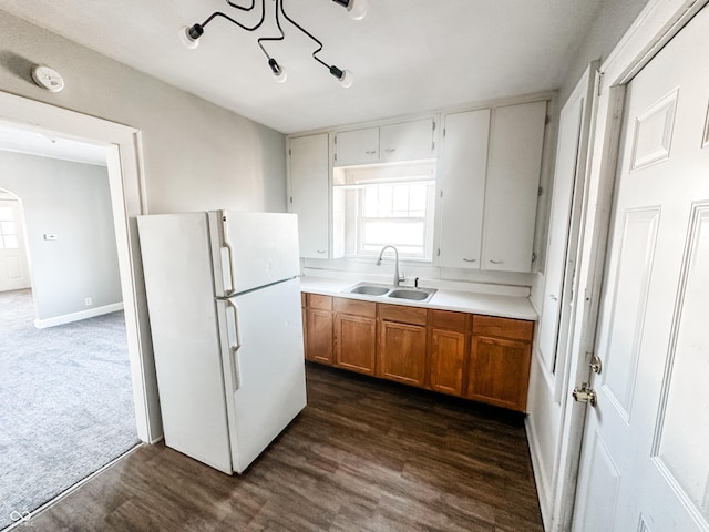 kitchen featuring white fridge, sink, and dark wood-type flooring