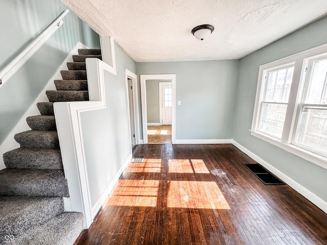 interior space with dark wood-type flooring and a textured ceiling