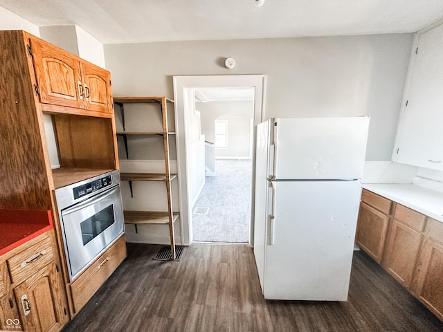 kitchen featuring white refrigerator, dark hardwood / wood-style floors, and oven