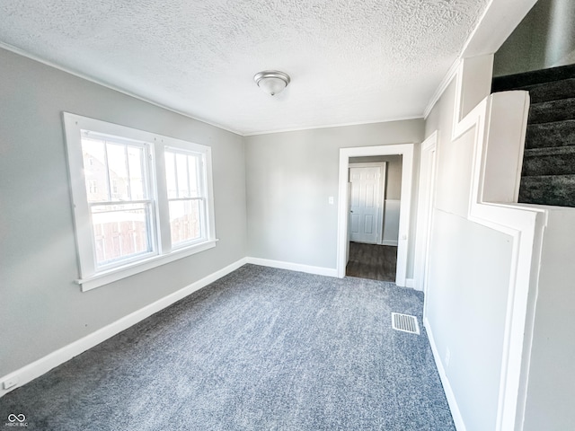 carpeted spare room featuring crown molding and a textured ceiling