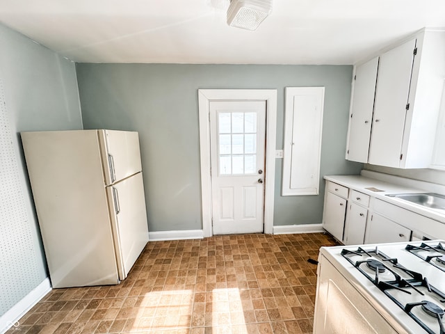 kitchen featuring white cabinetry, sink, and white appliances