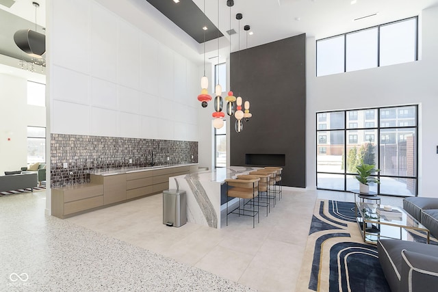 kitchen featuring a high ceiling, pendant lighting, and decorative backsplash