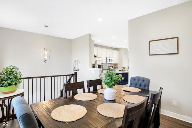 dining area featuring a notable chandelier and dark hardwood / wood-style floors