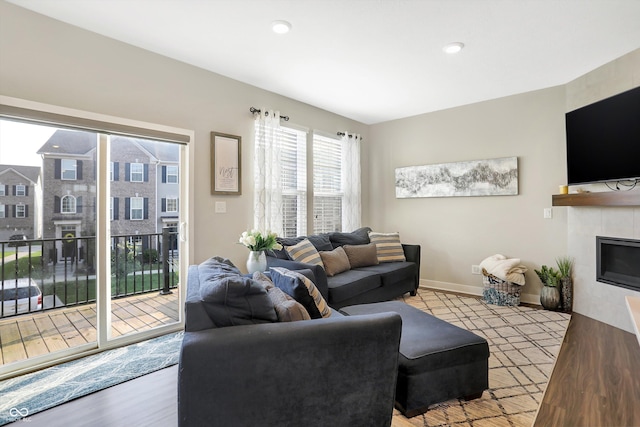 living room featuring a tiled fireplace and light hardwood / wood-style flooring