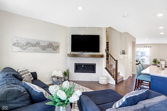 living room featuring a fireplace, dark hardwood / wood-style floors, and sink