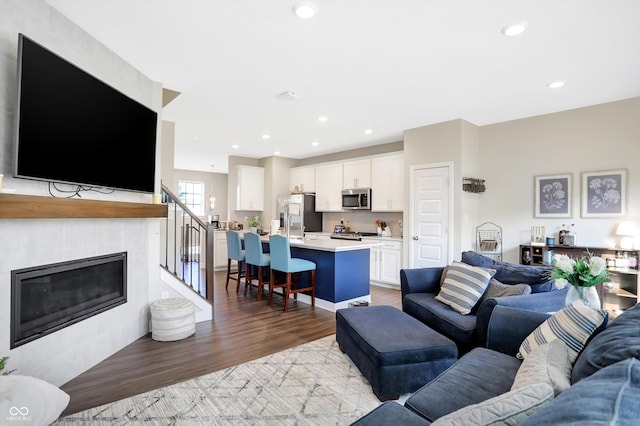 living room with a fireplace and light wood-type flooring