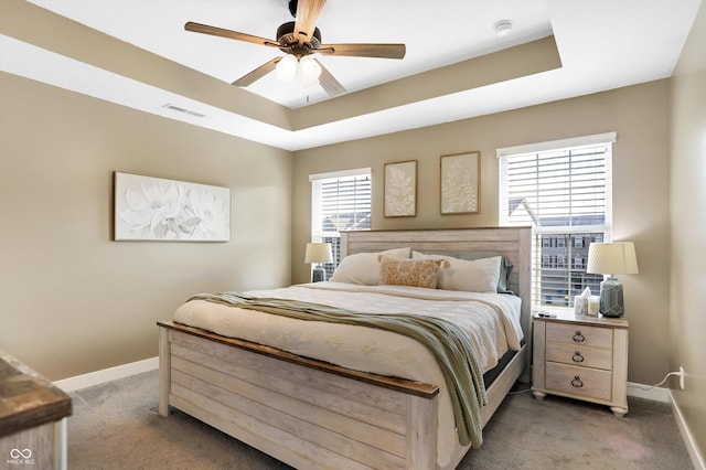 bedroom featuring a raised ceiling, carpet, and ceiling fan