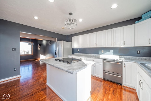 kitchen with hanging light fixtures, white cabinets, a kitchen island, stainless steel fridge with ice dispenser, and a chandelier