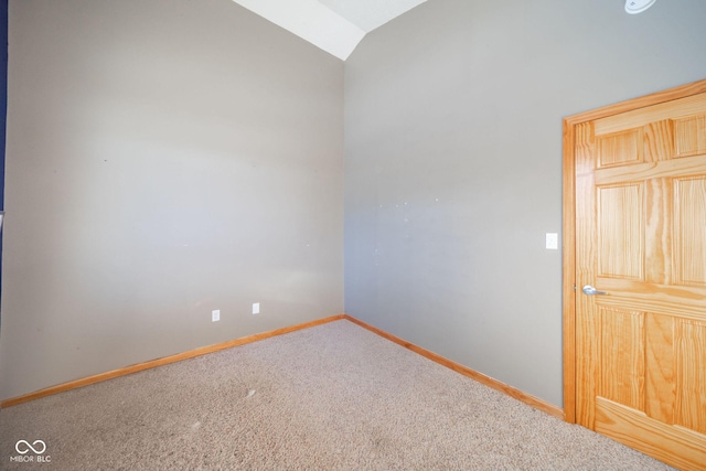 unfurnished room featuring vaulted ceiling and carpet flooring