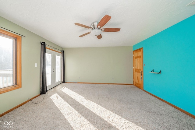 spare room with ceiling fan, light carpet, and a textured ceiling