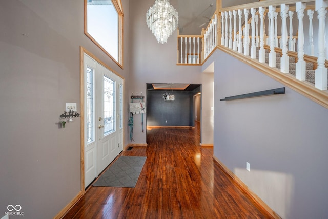 entryway with wood-type flooring, a high ceiling, and a notable chandelier