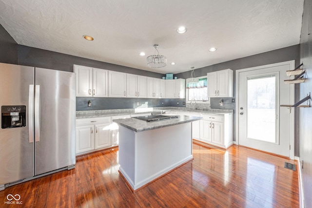 kitchen featuring a kitchen island, decorative light fixtures, white cabinetry, dark hardwood / wood-style flooring, and stainless steel fridge with ice dispenser