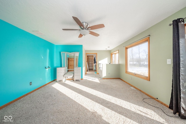 interior space with ceiling fan and carpet flooring