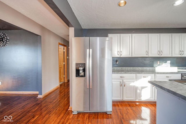 kitchen with white cabinetry, hardwood / wood-style flooring, and stainless steel fridge