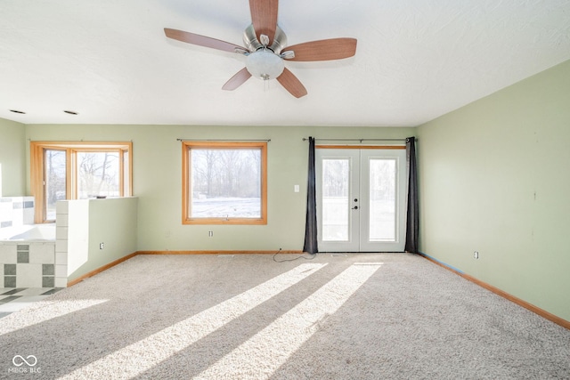 spare room featuring light carpet, a wealth of natural light, and french doors