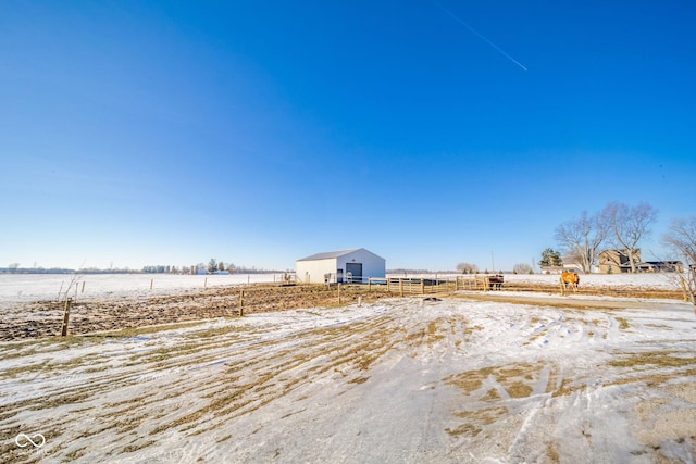 yard covered in snow featuring a rural view