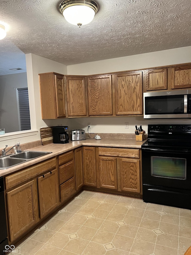 kitchen featuring light tile patterned floors, sink, a textured ceiling, and black appliances