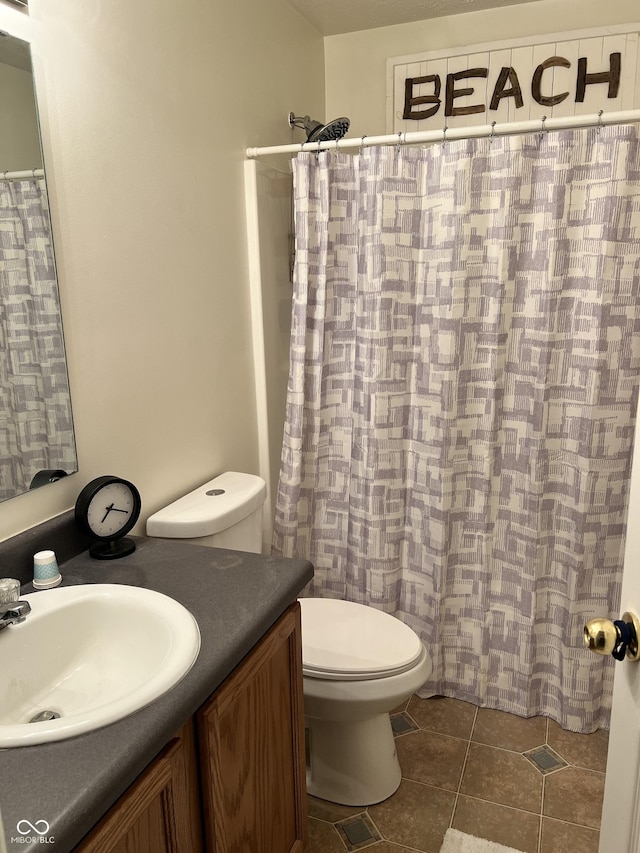 bathroom featuring a shower with shower curtain, vanity, toilet, and tile patterned flooring