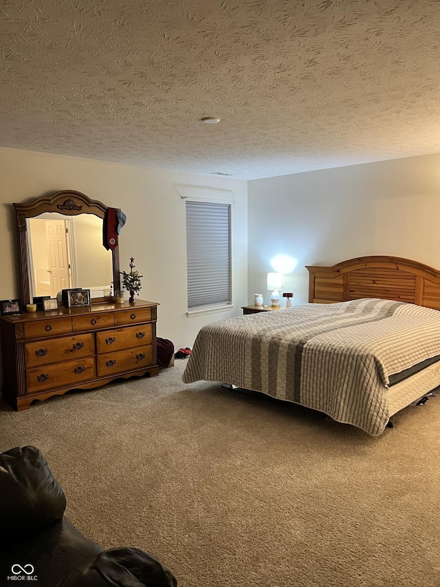 bedroom with carpet floors and a textured ceiling