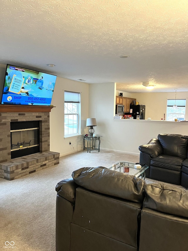 living room with a brick fireplace, a textured ceiling, and carpet flooring