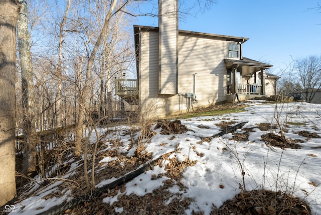 view of snowy exterior with covered porch