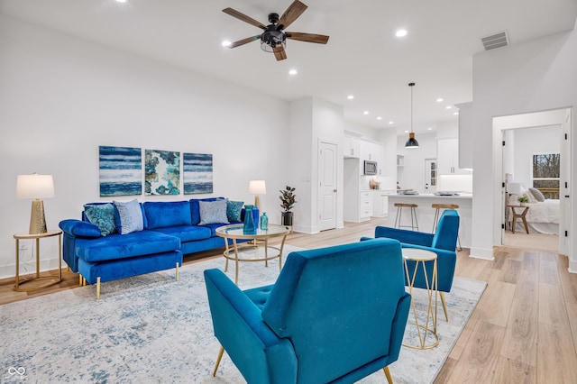 living room with light hardwood / wood-style flooring and ceiling fan