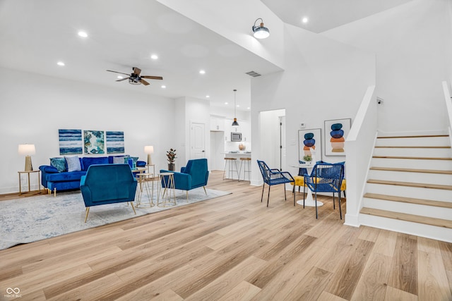 living room with light hardwood / wood-style flooring and ceiling fan