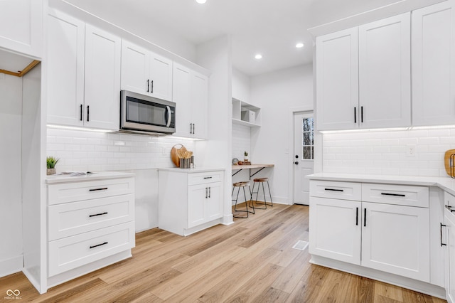 kitchen featuring backsplash, white cabinets, and light hardwood / wood-style floors