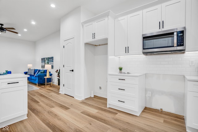 kitchen with backsplash, white cabinets, and ceiling fan