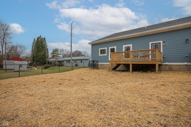 rear view of house with a deck and a lawn