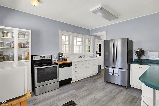 kitchen with stainless steel appliances, a sink, visible vents, white cabinets, and light wood-type flooring