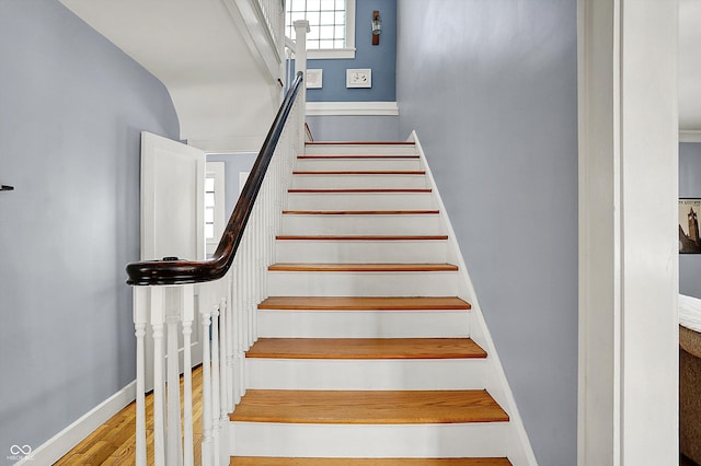 stairway with baseboards and wood finished floors