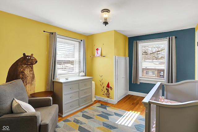 living area with a healthy amount of sunlight, light wood-style flooring, and baseboards