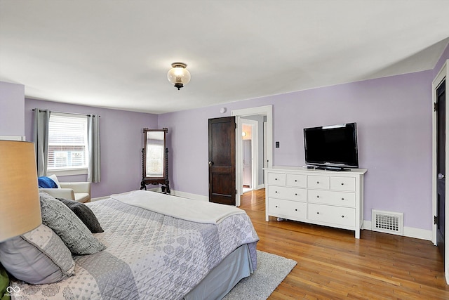 bedroom featuring light wood-style floors, baseboards, and visible vents