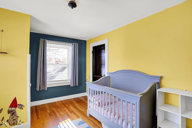 bedroom with wood finished floors and baseboards