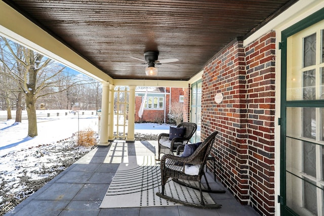 snow covered patio featuring ceiling fan