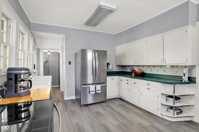 kitchen featuring dark countertops, white cabinetry, and freestanding refrigerator