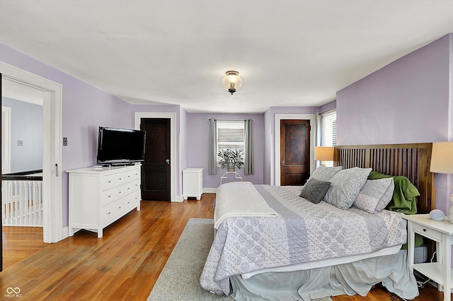 bedroom with radiator, light wood-style flooring, and baseboards