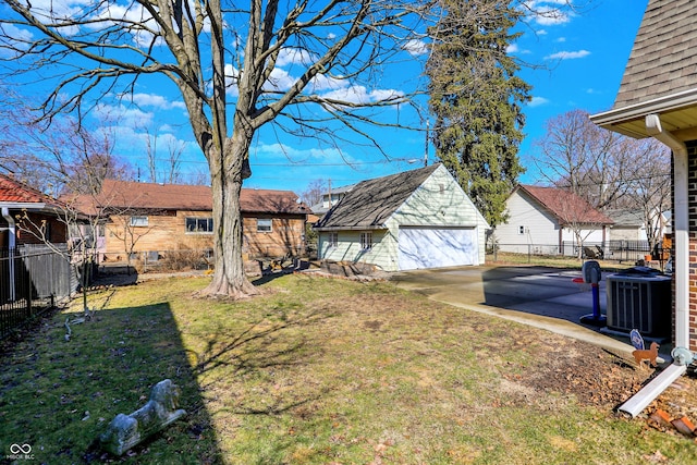 view of yard featuring central AC, an outdoor structure, a detached garage, and fence