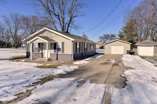 view of snowy exterior with an outbuilding and a garage