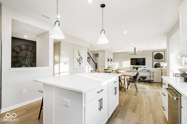 kitchen with light countertops, light wood-style flooring, visible vents, and white cabinets