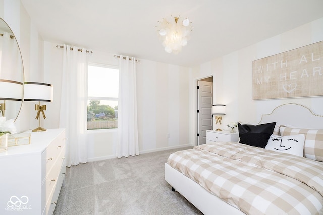 bedroom with a notable chandelier, light colored carpet, and baseboards