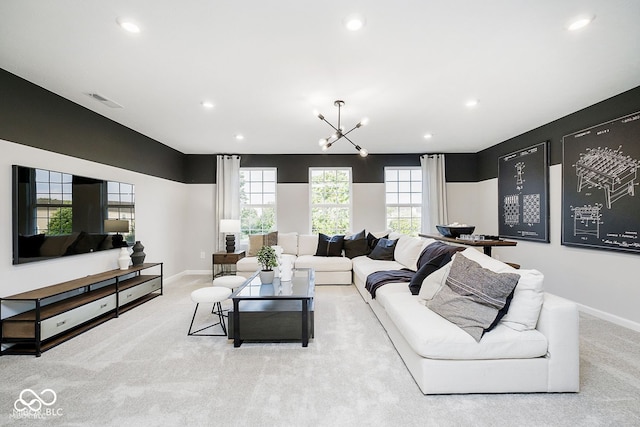 living room with a wealth of natural light, light colored carpet, an inviting chandelier, and recessed lighting