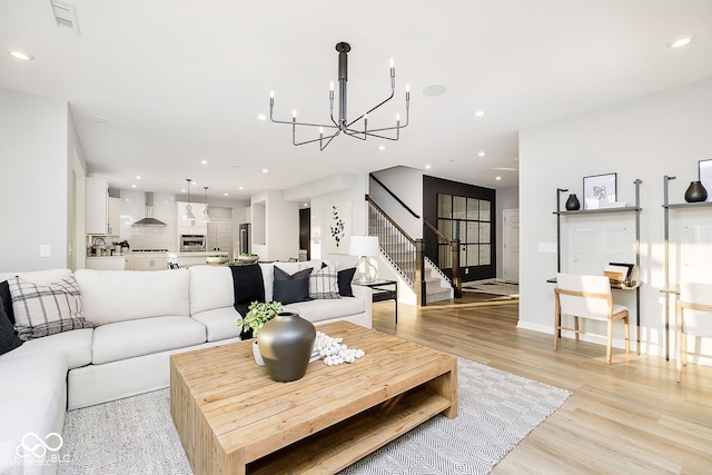 living area with light wood finished floors, visible vents, recessed lighting, and stairs