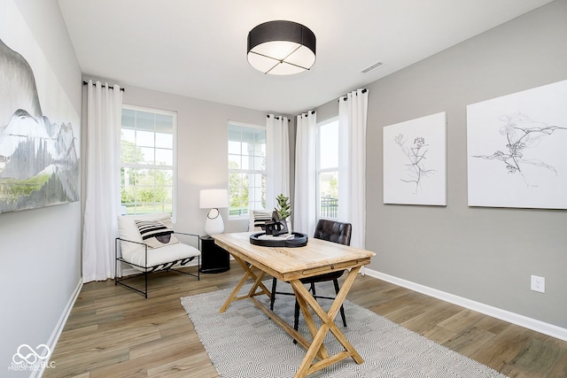 home office featuring visible vents, light wood-style flooring, and baseboards