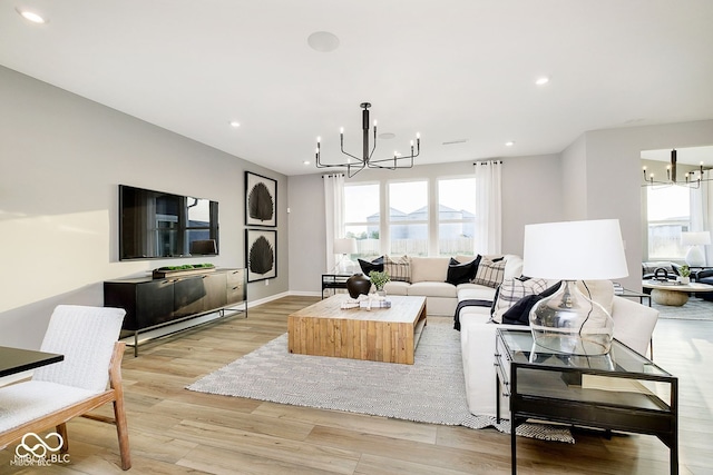 living area with recessed lighting, light wood-style floors, baseboards, and a chandelier