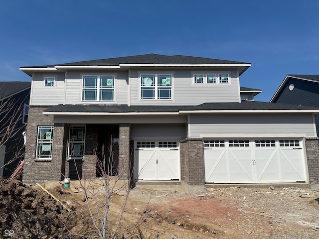 prairie-style house featuring brick siding and an attached garage